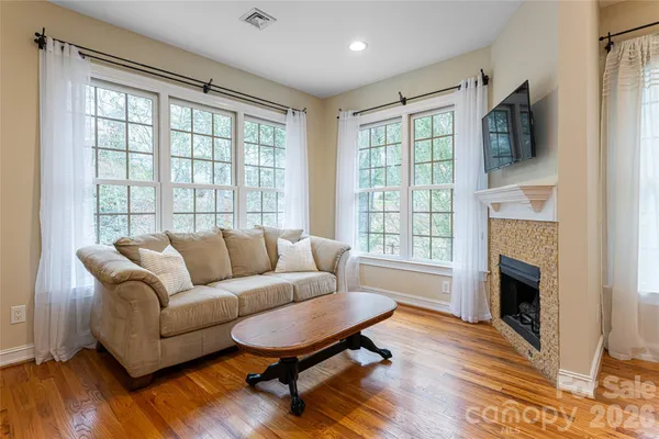 a living room with furniture a fireplace and a flat screen tv