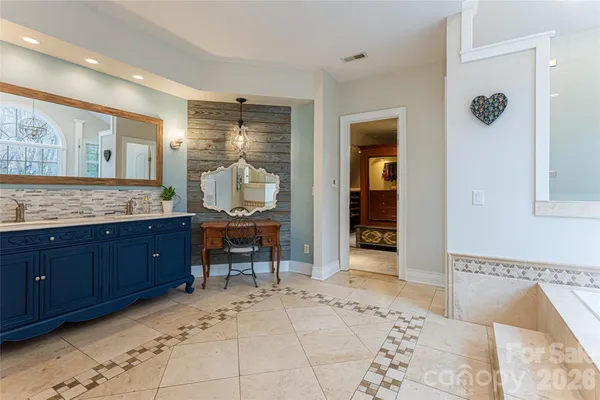 a spacious bathroom with a granite countertop sink and a mirror