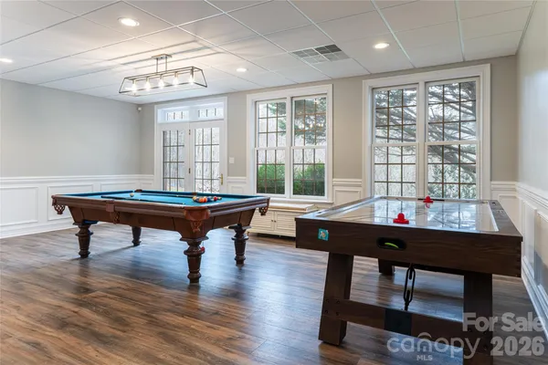 a room with furniture pool table and windows
