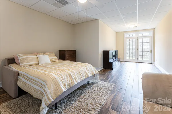 a bedroom with a large bed and wooden floor