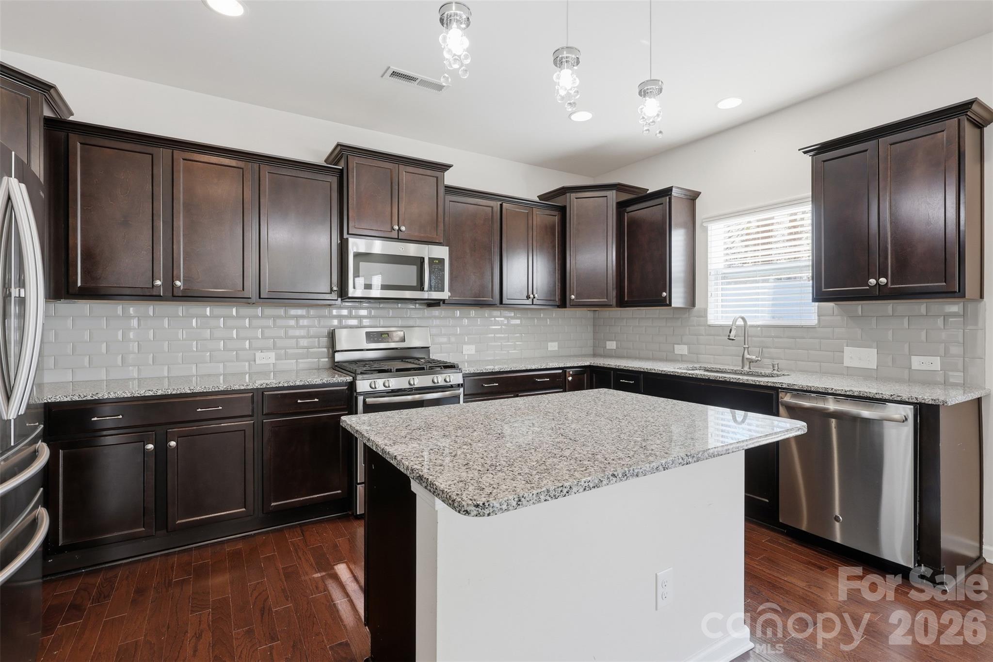 1722 Still River Way Fort Mill, SC 29708 - Photo 15 of 45 a kitchen with stainless steel appliances granite countertop a sink stove microwave and cabinets