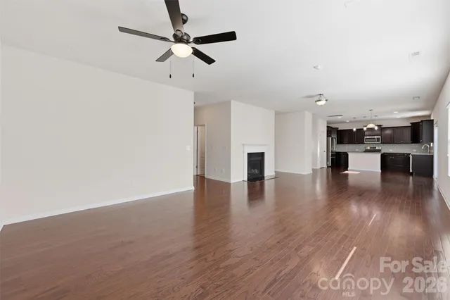 a kitchen with stainless steel appliances granite countertop a stove top oven a refrigerator and a granite counter tops with wooden floors