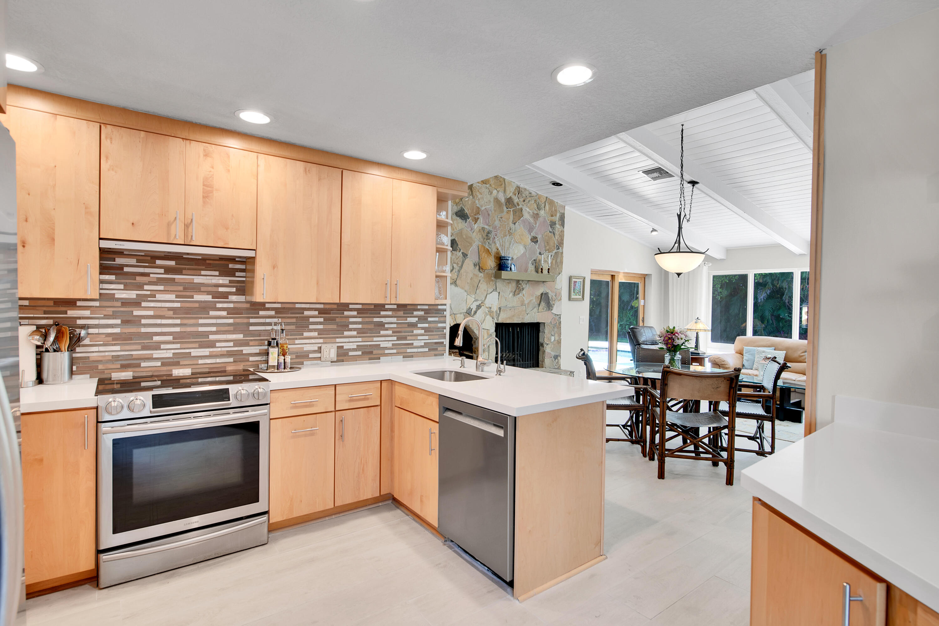 2932 Banyan Blvd Circle Northwest Boca Raton, FL 33431 - Photo 17 of 57 a kitchen with a stove a sink and white cabinets