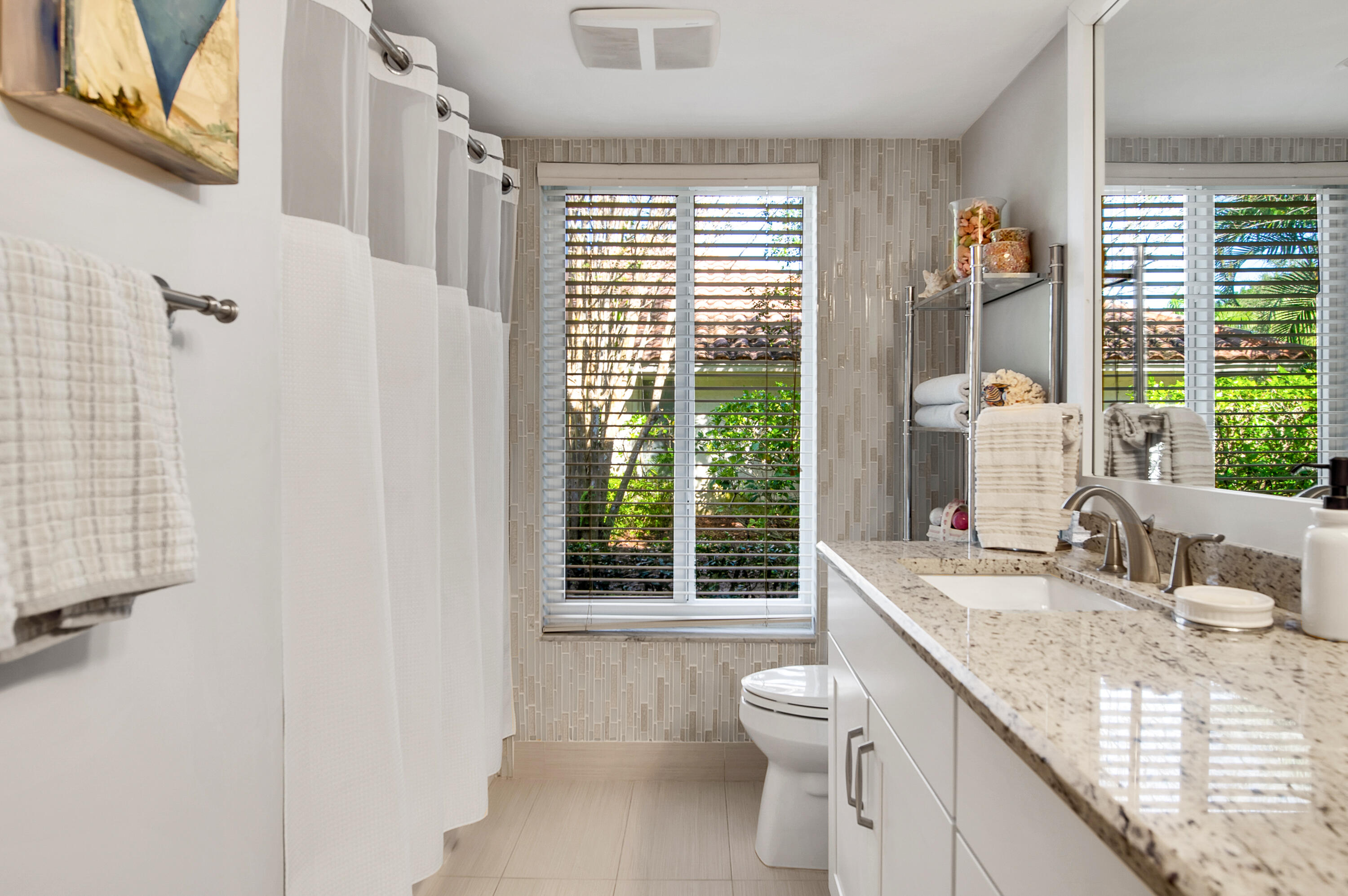 2932 Banyan Blvd Circle Northwest Boca Raton, FL 33431 - Photo 32 of 57 a bathroom with a granite countertop sink a toilet a large mirror next to a window