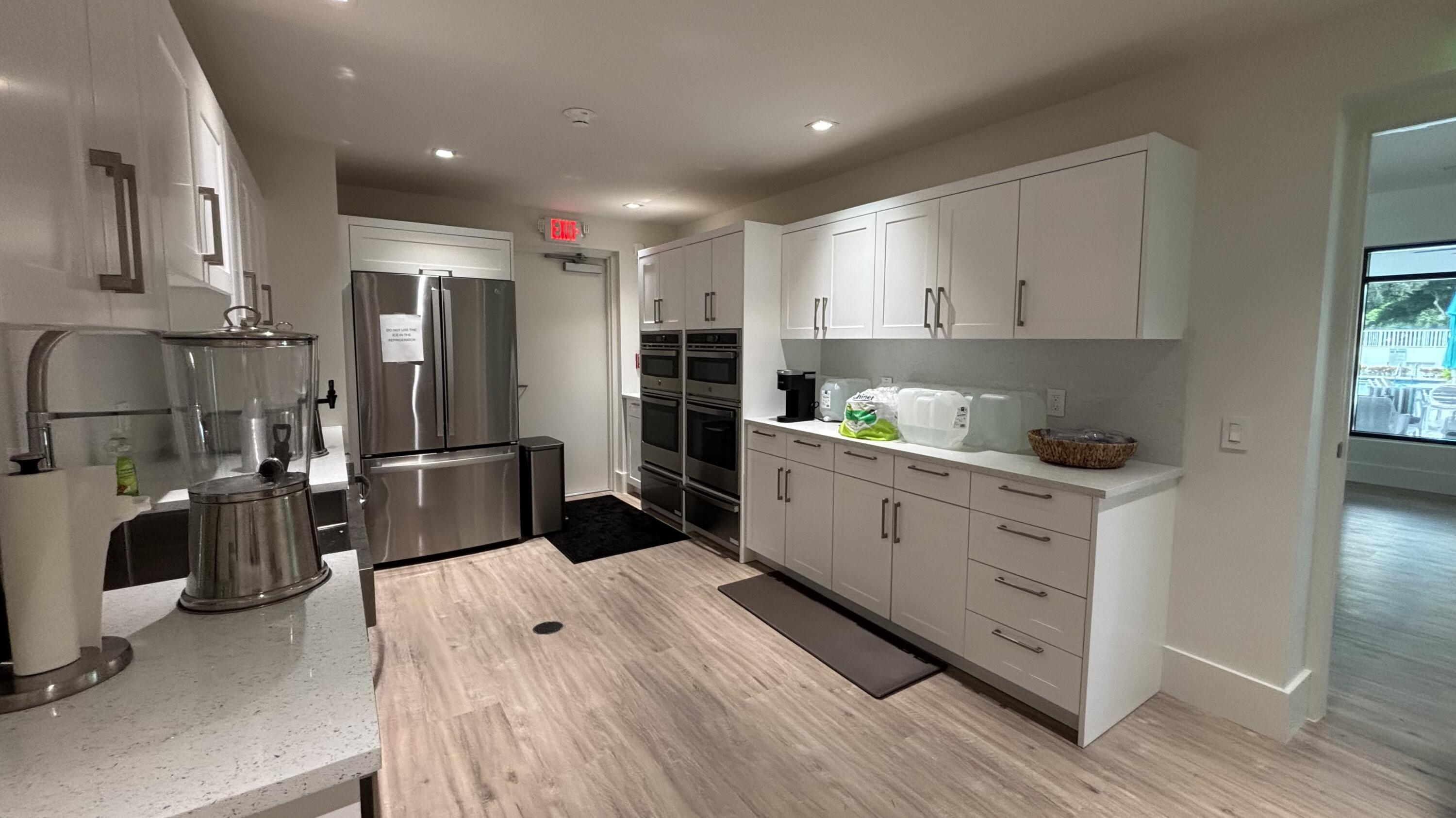 2932 Banyan Blvd Circle Northwest Boca Raton, FL 33431 - Photo 50 of 57 a kitchen with stainless steel appliances kitchen island granite countertop a refrigerator sink and white cabinets