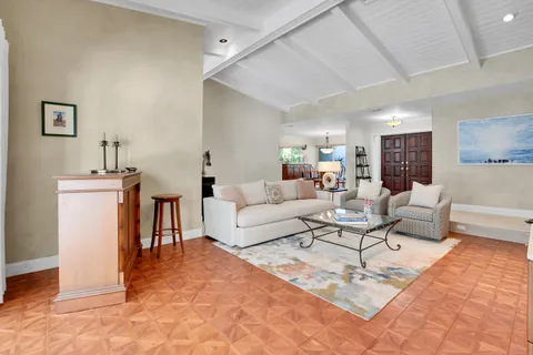 a living room with furniture a rug and white walls