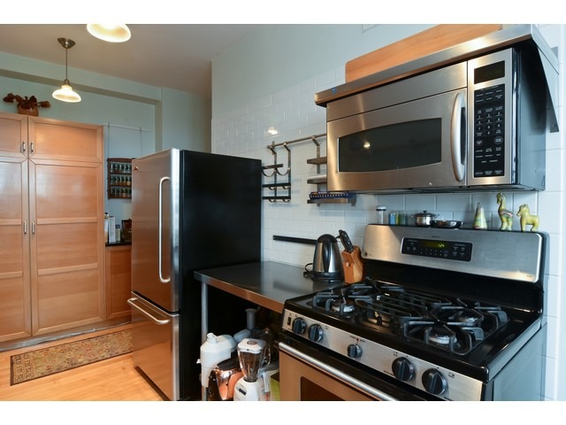 6342 North Sheridan Road, Unit 5B Chicago, IL 60660 - Photo 11 of 25 a kitchen with stainless steel appliances granite countertop a refrigerator and a stove top oven