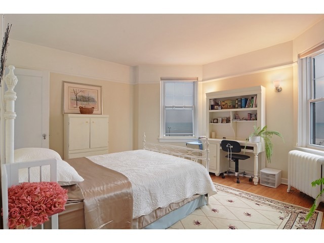 6342 North Sheridan Road, Unit 5B Chicago, IL 60660 - Photo 14 of 25 a bedroom with a bed and a chair with the wooden floor