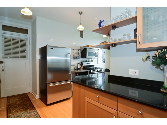 6342 North Sheridan Road, Unit 5B Chicago, IL 60660 - Photo 8 of 25 a kitchen with stainless steel appliances granite countertop a refrigerator and a sink
