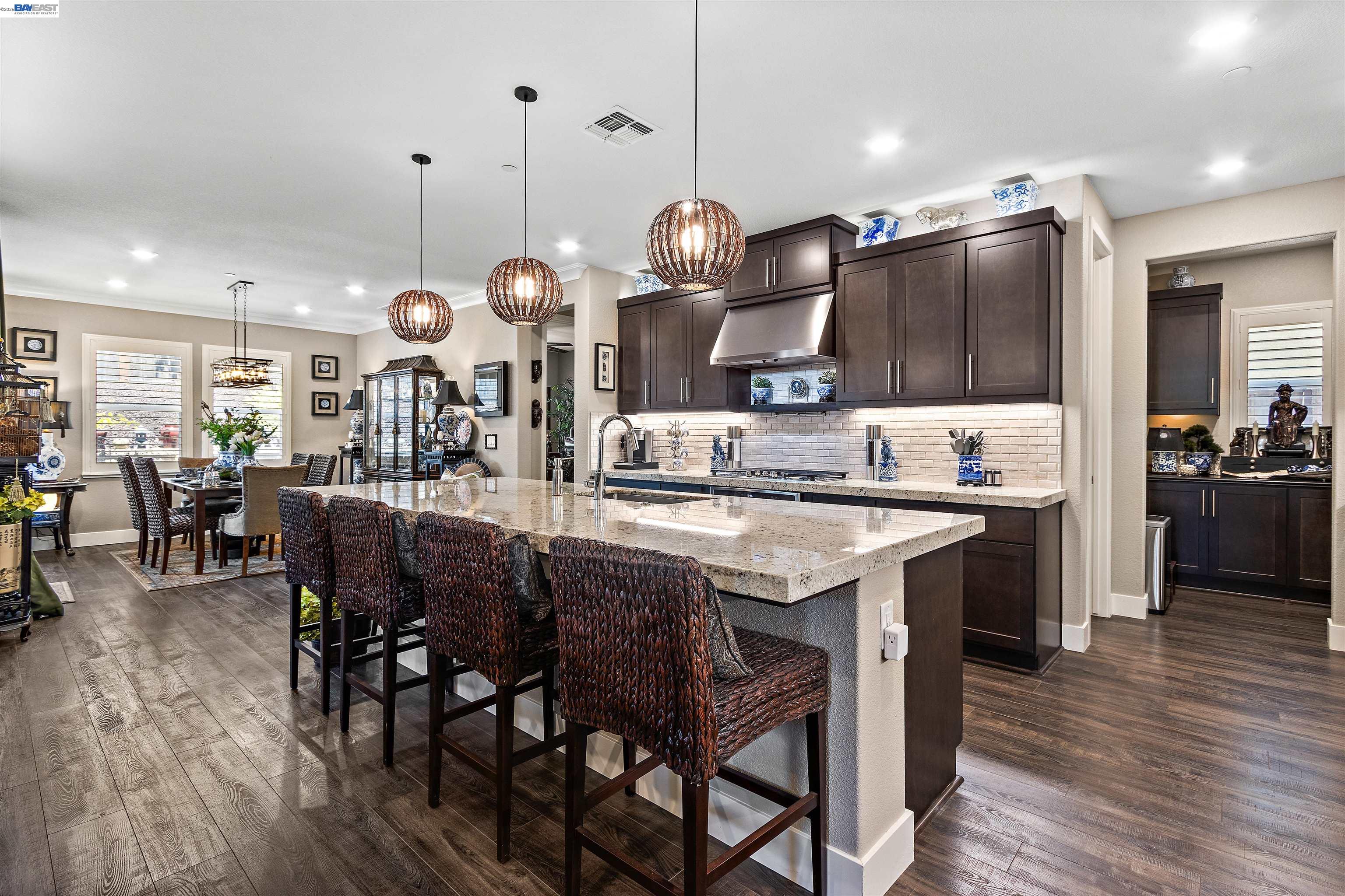 a kitchen with a dining table chairs and wooden floor