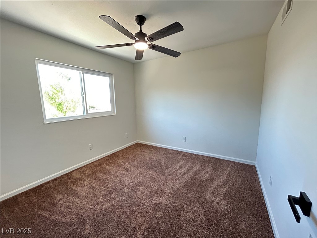 5035 Meadow Grove Court Las Vegas, NV 89120 - Photo 12 of 23 Unfurnished room featuring dark carpet and a ceiling fan