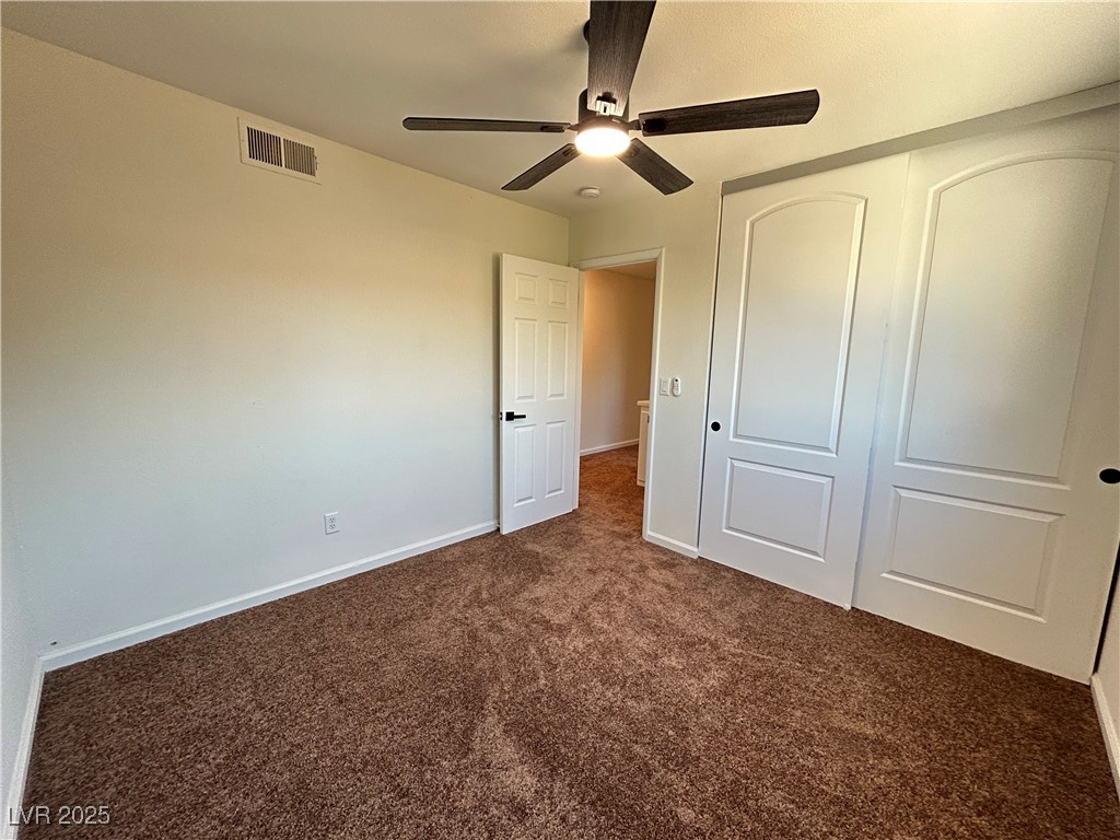 5035 Meadow Grove Court Las Vegas, NV 89120 - Photo 13 of 23 Unfurnished bedroom featuring dark colored carpet, a closet, and a ceiling fan