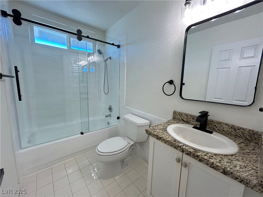 5035 Meadow Grove Court Las Vegas, NV 89120 - Photo 14 of 23 Full bathroom with vanity, combined bath / shower with glass door, light tile patterned floors, and a textured wall