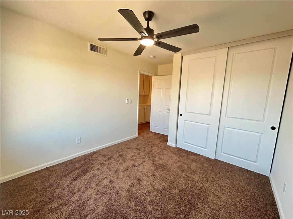 5035 Meadow Grove Court Las Vegas, NV 89120 - Photo 16 of 23 Unfurnished bedroom with dark colored carpet, a closet, and a ceiling fan