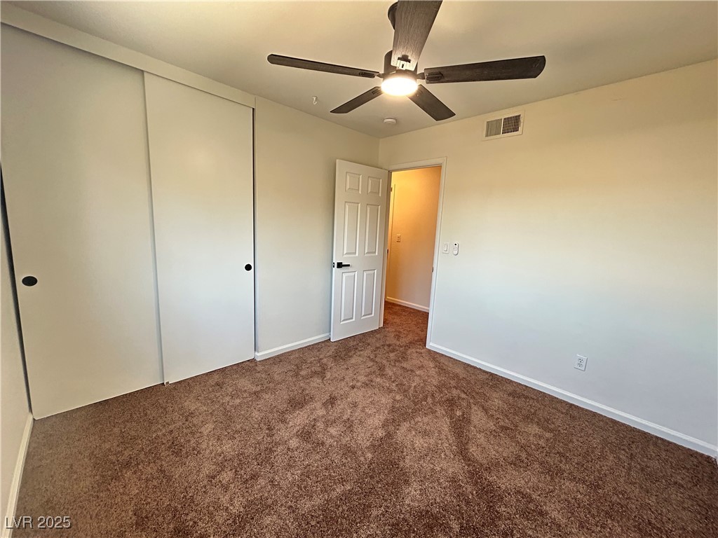 5035 Meadow Grove Court Las Vegas, NV 89120 - Photo 18 of 23 Unfurnished bedroom with dark carpet, a closet, and a ceiling fan