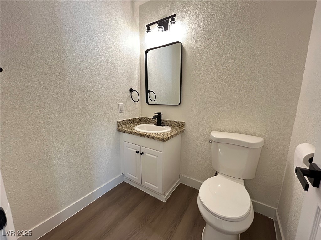 5035 Meadow Grove Court Las Vegas, NV 89120 - Photo 8 of 23 Bathroom with a textured wall, vanity, and dark wood finished floors
