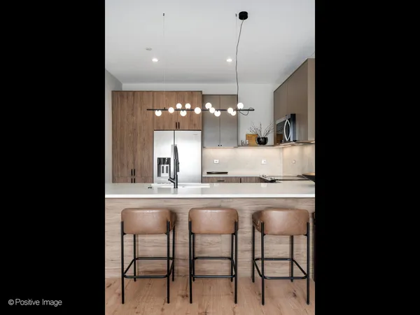 a kitchen with kitchen island granite countertop a table chairs sink and cabinets