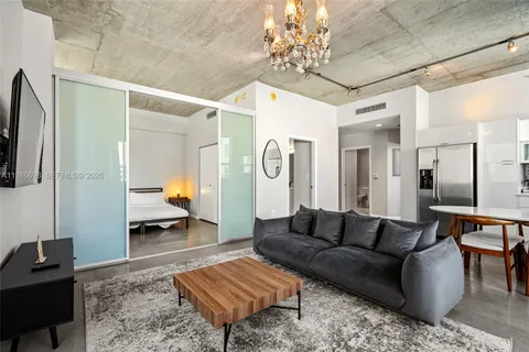 a living room with furniture and a chandelier