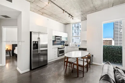a kitchen with refrigerator a sink and chairs