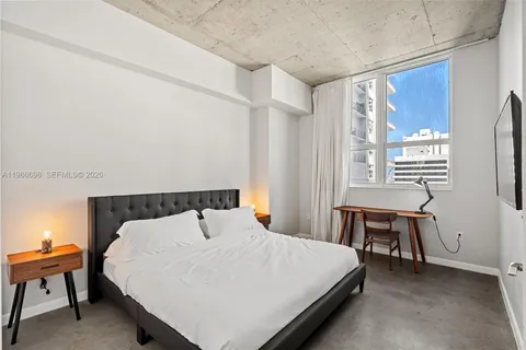 a bed sitting in a bedroom next to a window