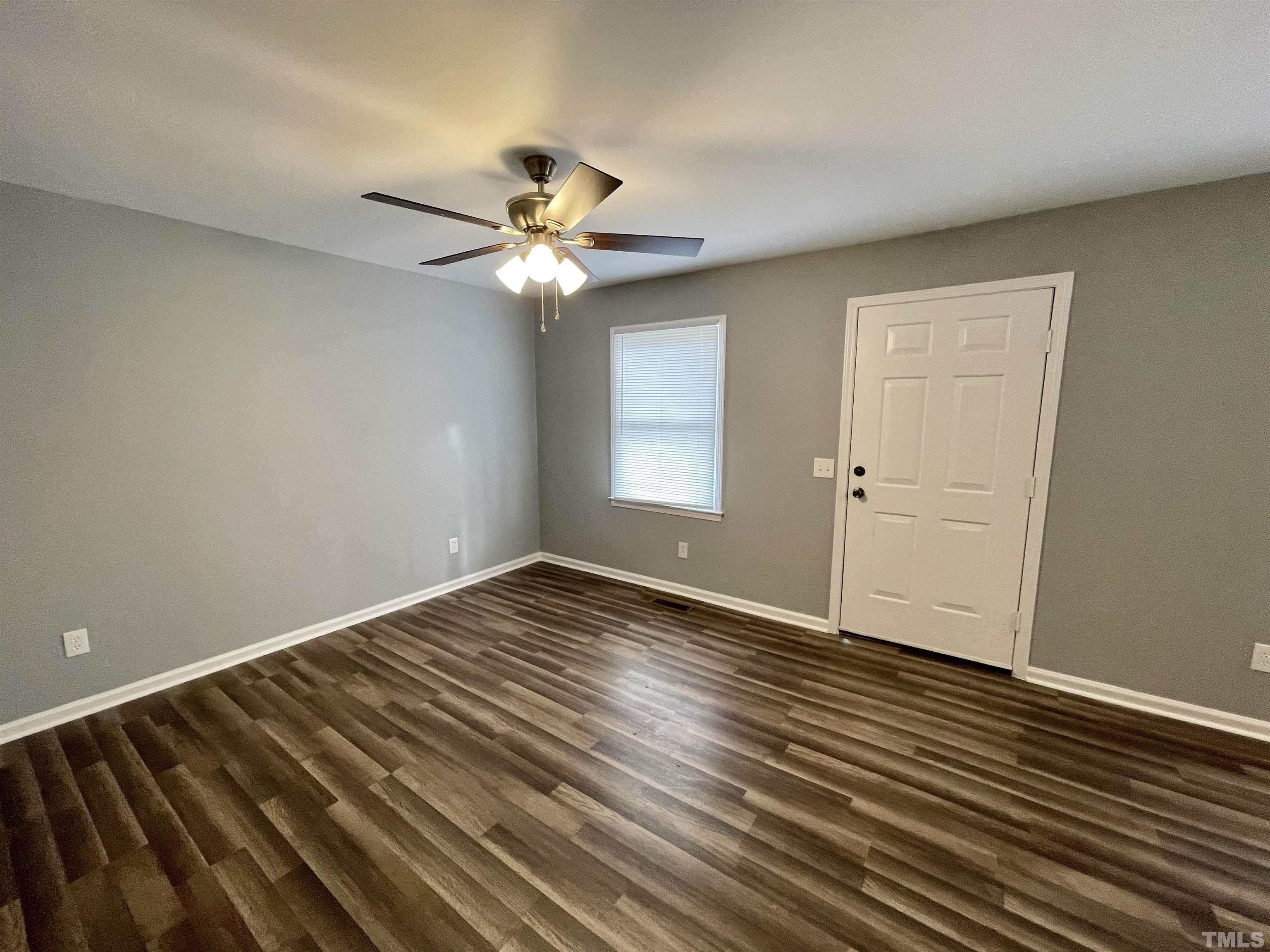 1421 Elm Street Roxboro, NC 27573 - Photo 8 of 13 an empty room with wooden floor fan and windows