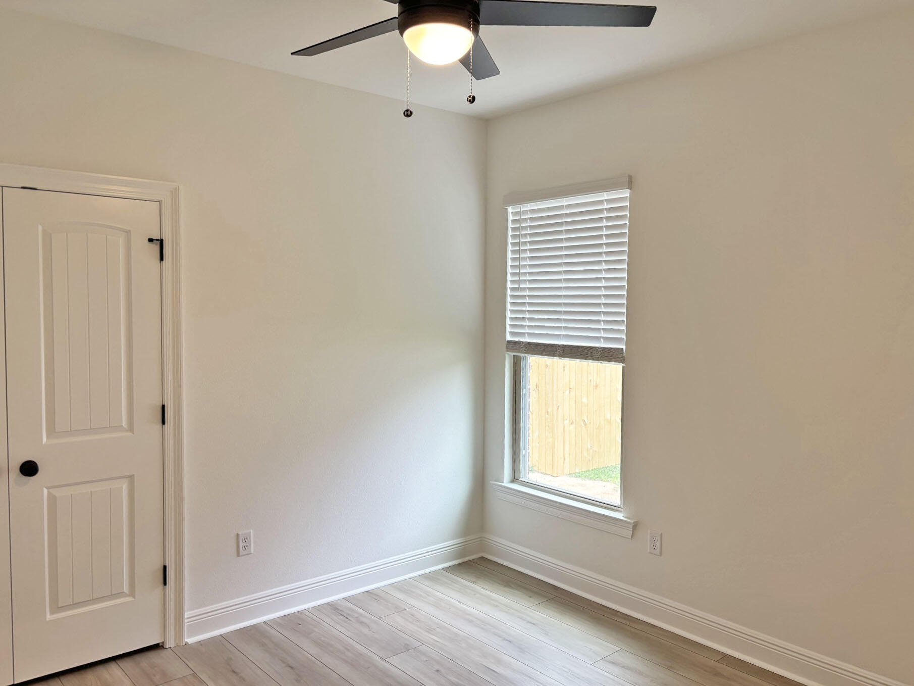 2745 Louis Circle Crestview, FL 32536 - Photo 11 of 18 an empty room with wooden floor and windows