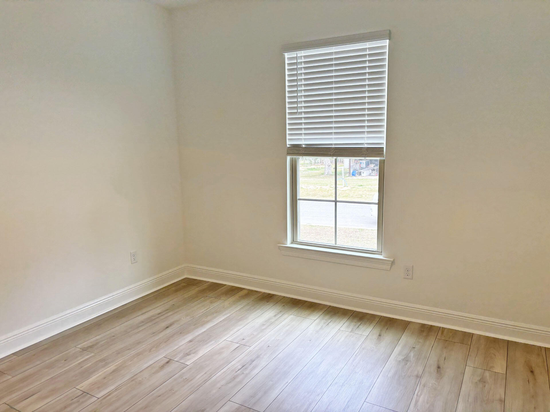 2745 Louis Circle Crestview, FL 32536 - Photo 12 of 18 an empty room with wooden floor and windows