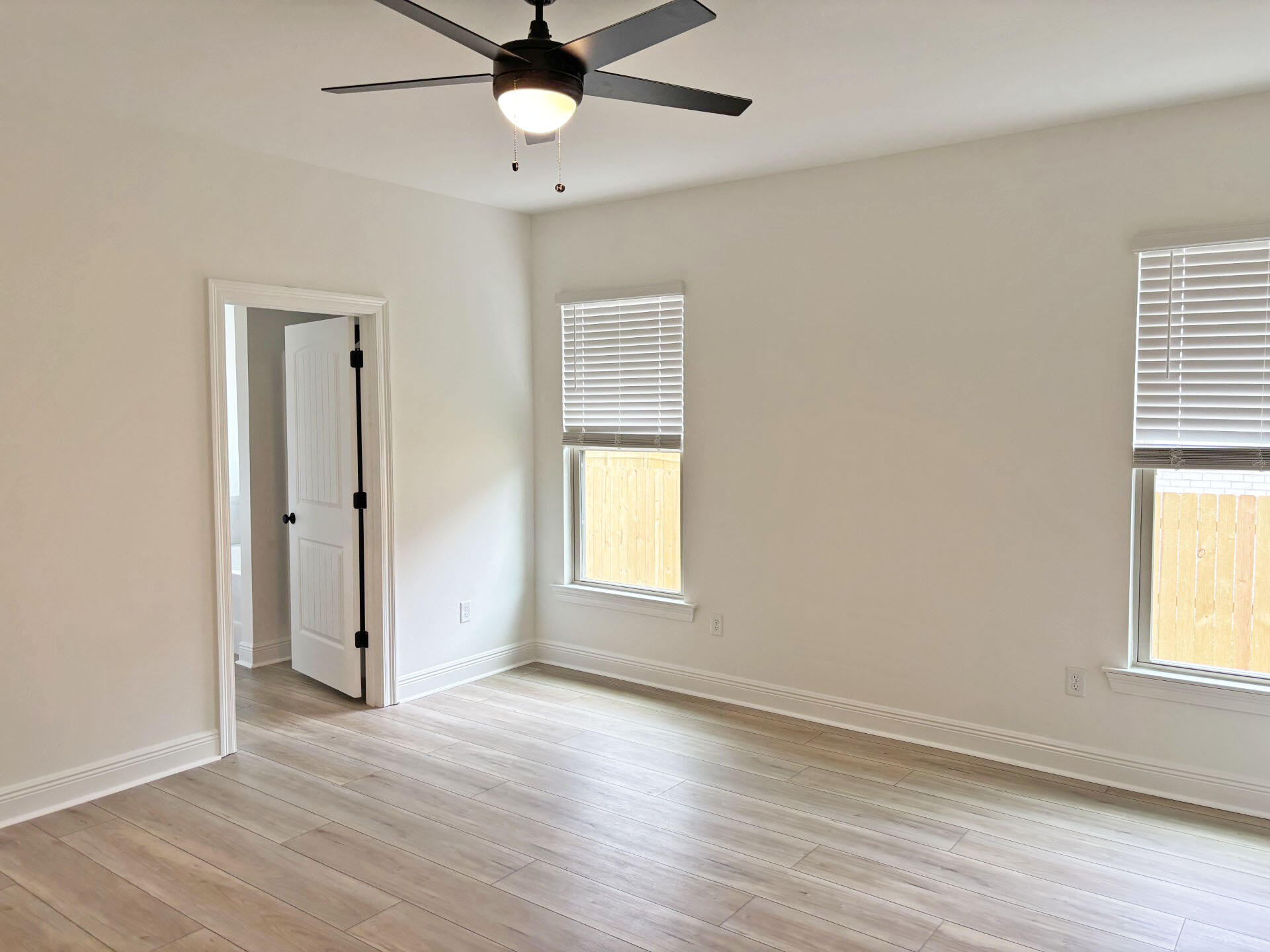 2745 Louis Circle Crestview, FL 32536 - Photo 7 of 18 an empty room with wooden floor and windows
