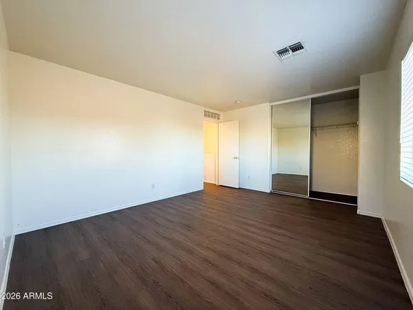 a view of an empty room with wooden floor