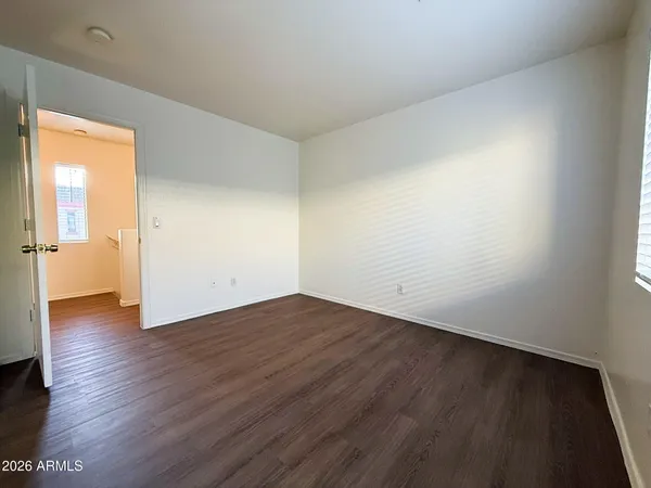 an empty room with wooden floor and a window