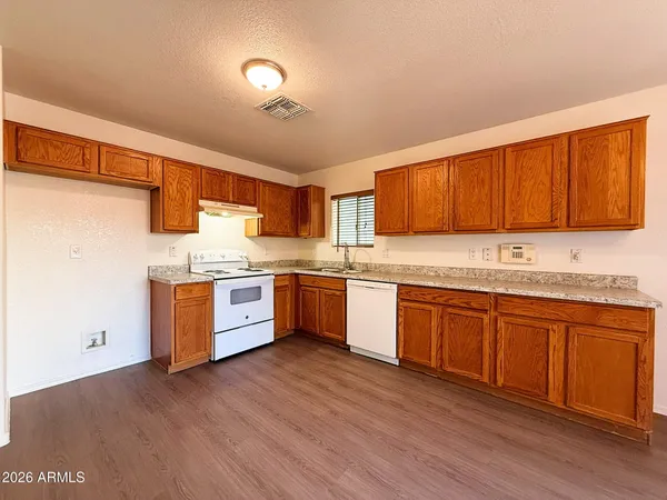 a large kitchen with stainless steel appliances granite countertop a stove a sink dishwasher and a refrigerator