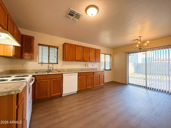 a large kitchen with stainless steel appliances granite countertop a stove a sink dishwasher and a oven with wooden floors
