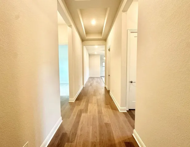 a view of a hallway with wooden floor