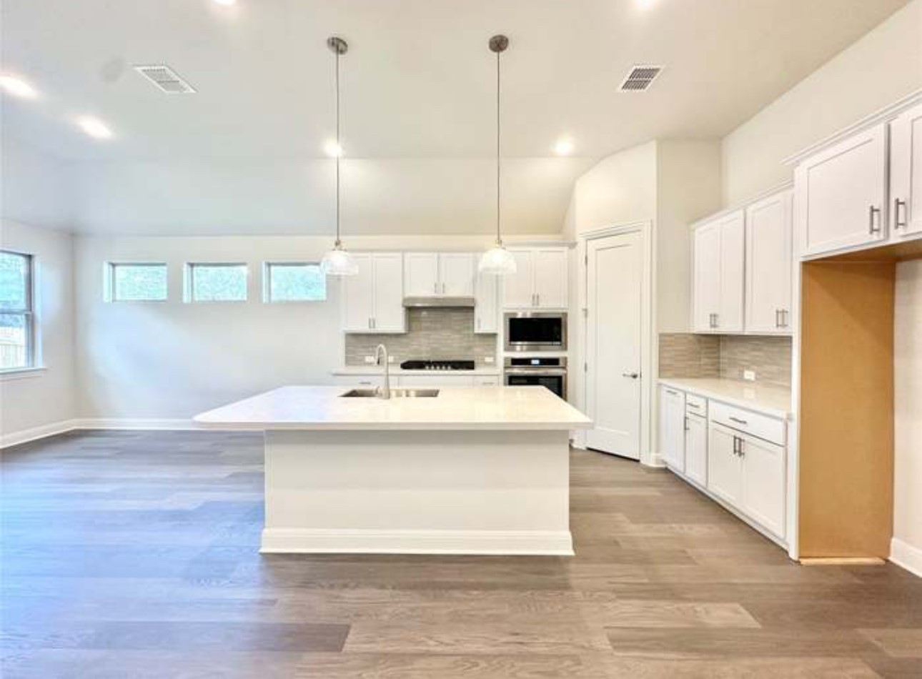 528 Tubman Drive Kyle, TX 78640 - Photo 4 of 27 a kitchen with kitchen island a white counter top space cabinets and stainless steel appliances