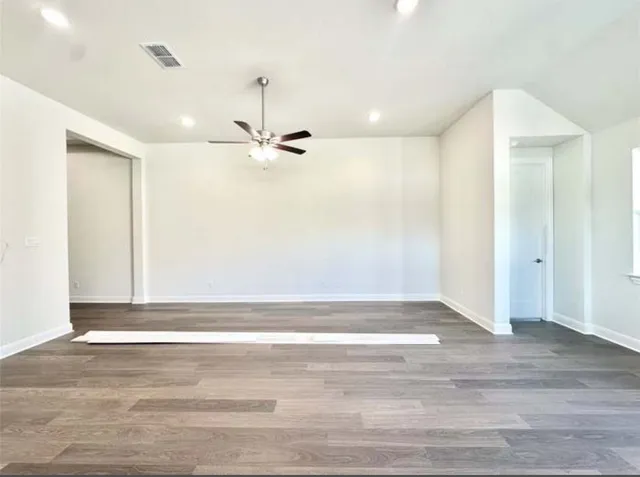 a view of a livingroom with a ceiling fan and hardwood floor