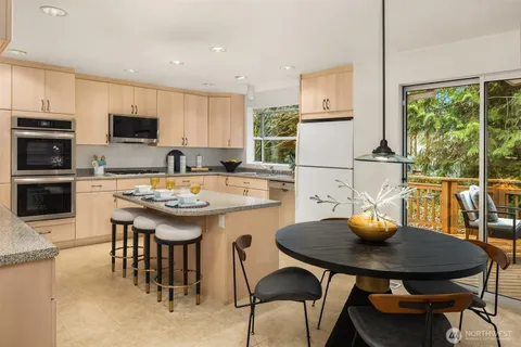 a kitchen with a stove a sink a microwave and a dining table