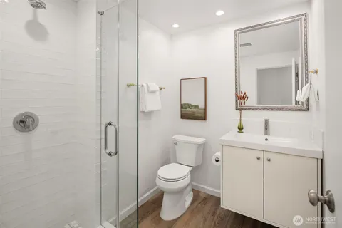a bathroom with a toilet a sink a mirror and vanity
