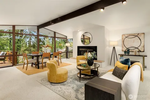 a living room with fireplace furniture and a floor to ceiling window