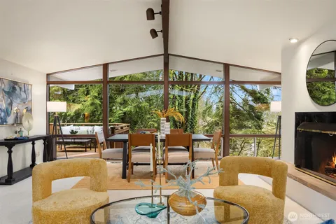 a living room with furniture a flat screen tv and a floor to ceiling window