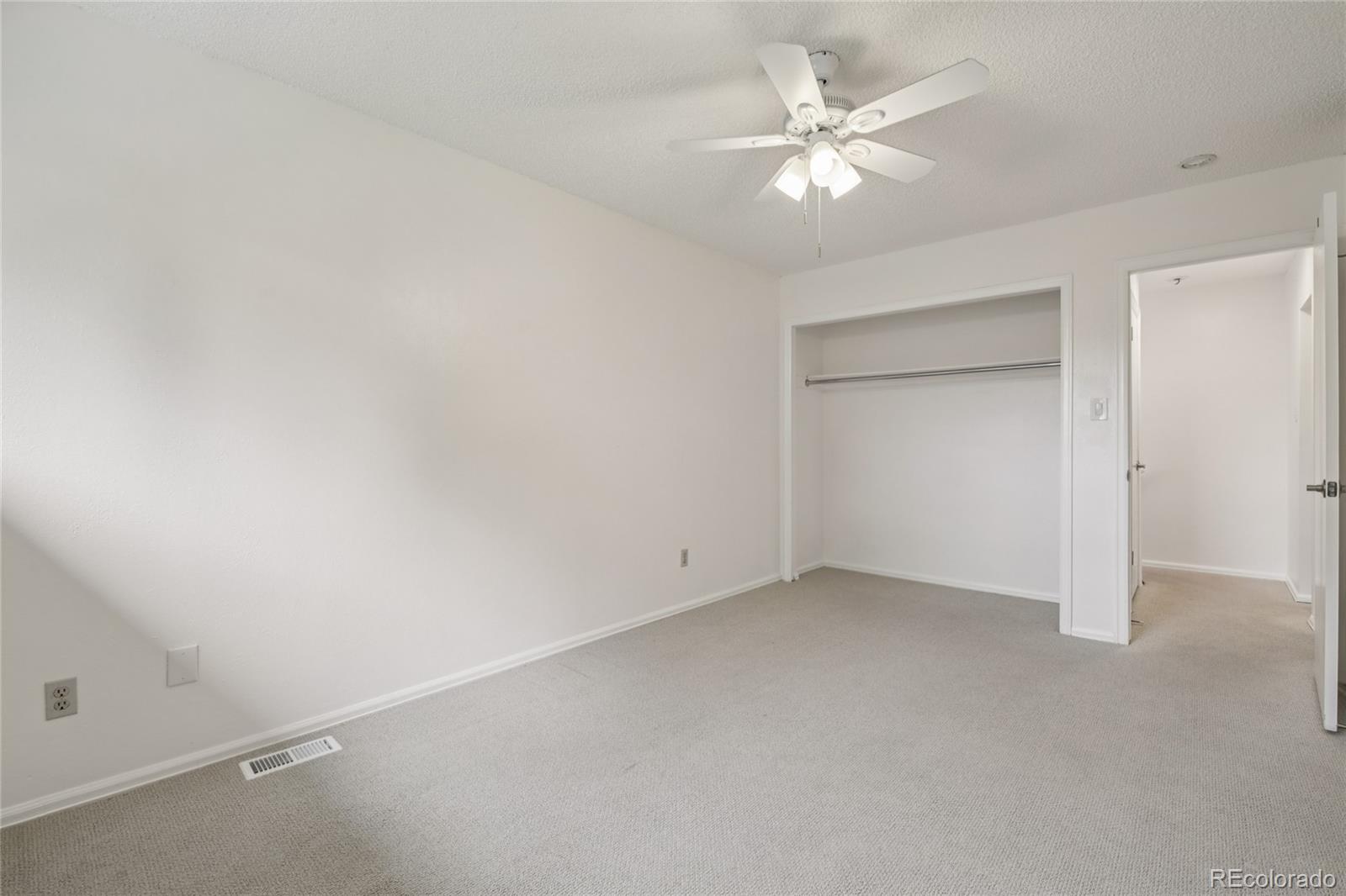 1169 Monroe Drive, Unit B Boulder, CO 80303 - Photo 19 of 32 an empty room with a chandelier fan and windows