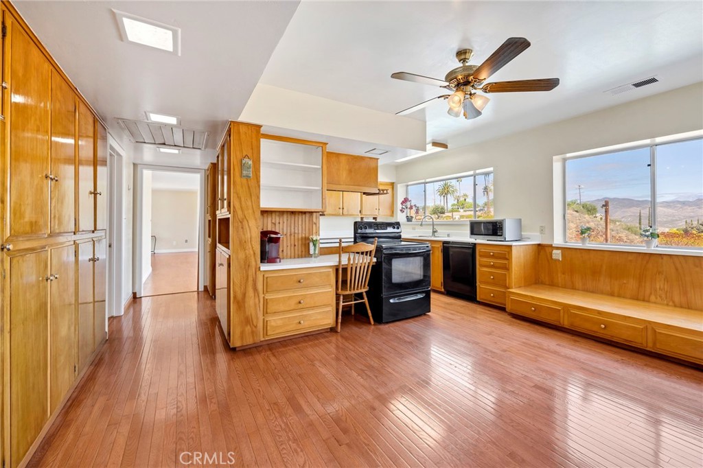 26320 Rim Road Hemet, CA 92544 - Photo 23 of 50 a kitchen with stainless steel appliances kitchen island granite countertop a stove a refrigerator a sink a dining table and chairs with wooden floor