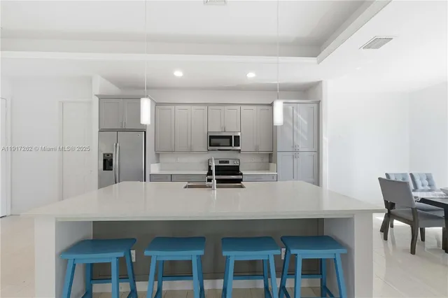 a kitchen with a table chairs microwave and refrigerator