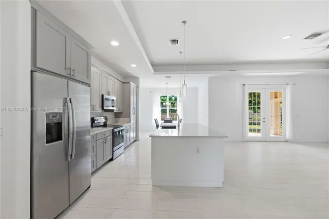a kitchen with stainless steel appliances a refrigerator and a stove top oven