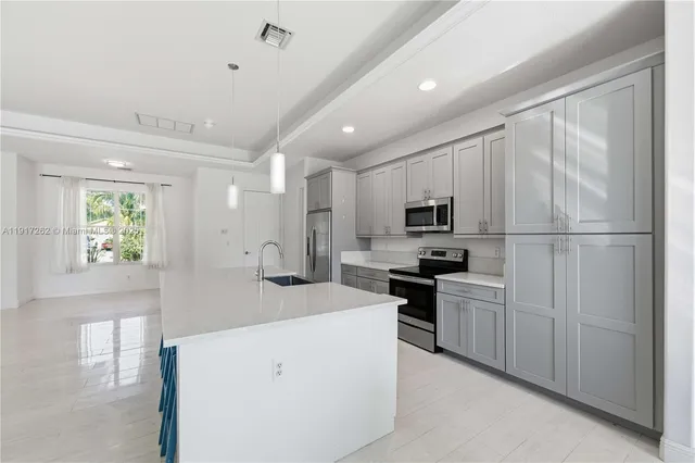 a kitchen with appliances a sink and a refrigerator