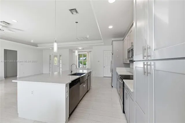 a kitchen with stainless steel appliances granite countertop a sink and a refrigerator