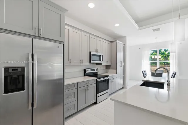 a kitchen with cabinets stainless steel appliances and a window
