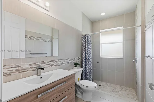 a bathroom with a sink toilet a mirror and shower