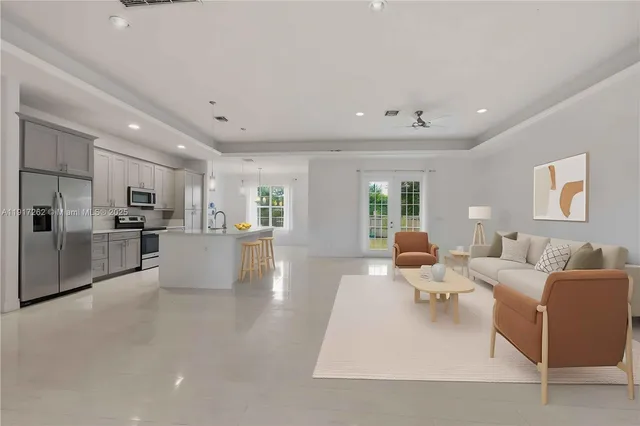 a living room with furniture white walls and kitchen view
