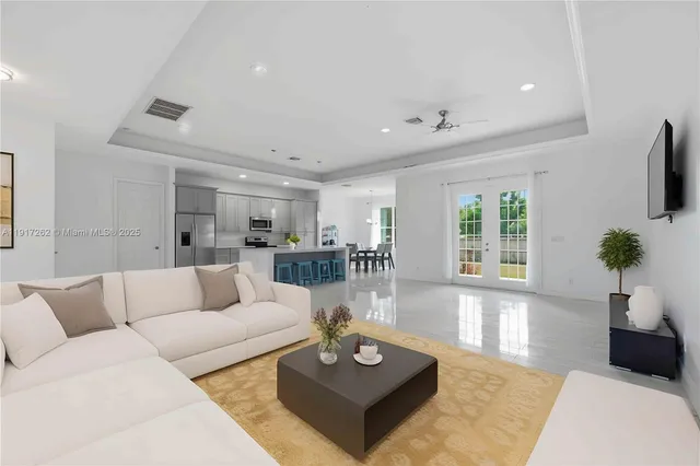 a living room with furniture a flat screen tv and a large window