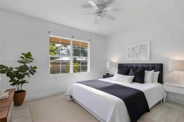 a bedroom with a bed and a potted plant